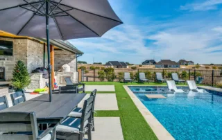 Modern backyard pool with tanning ledge and in-water lounge chairs