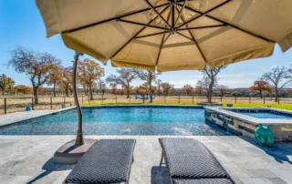 Modern backyard pool with tanning ledge and in-water lounge chairs