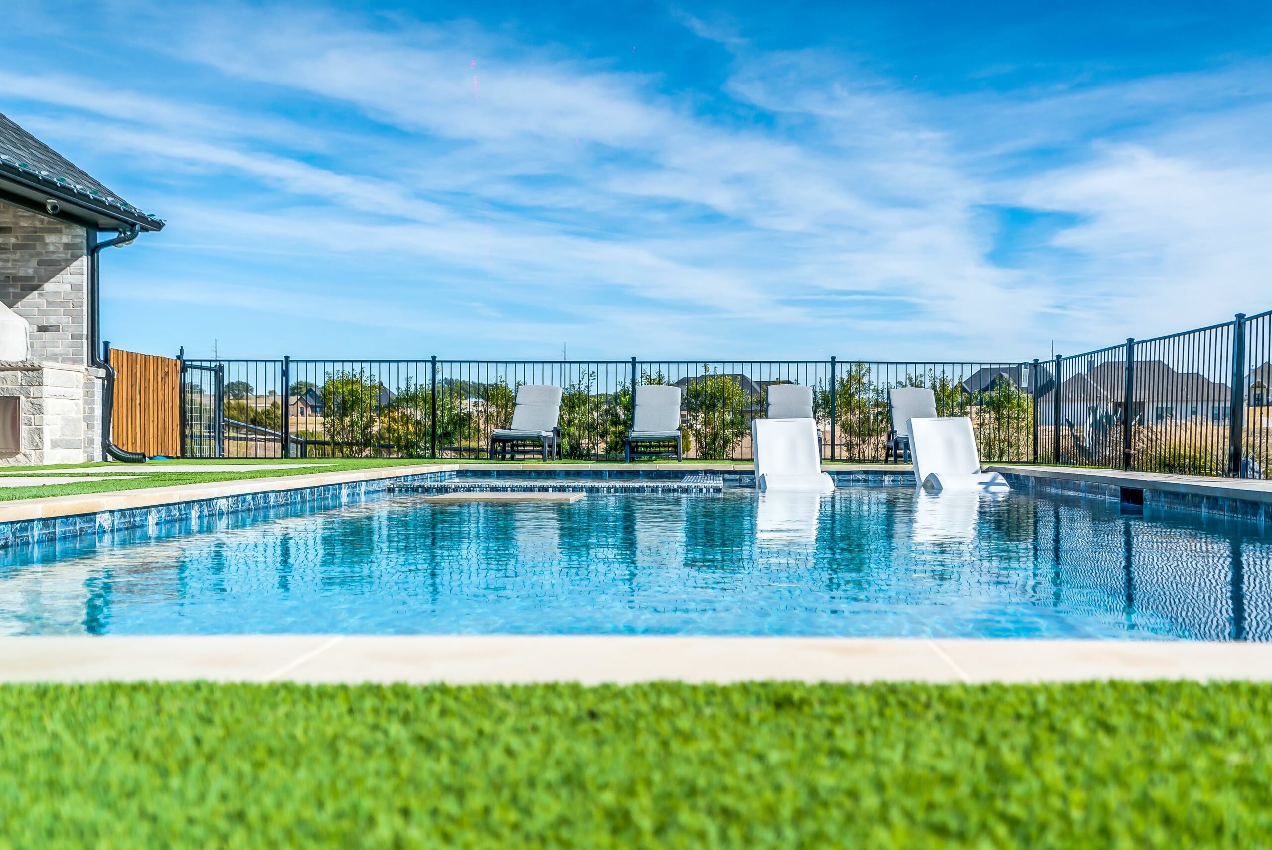 DSC00207BLENDED-min Luxury geometric pool with in-water lounge chairs and modern black perimeter fencing